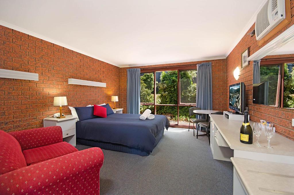 波特兰捕鲸者休闲汽车旅馆的一间卧室配有一张床、一张沙发和一台电视。