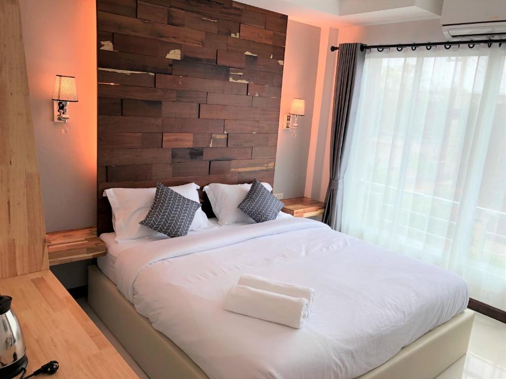 南府Nan Panwa Hotel的卧室配有一张白色大床和木墙