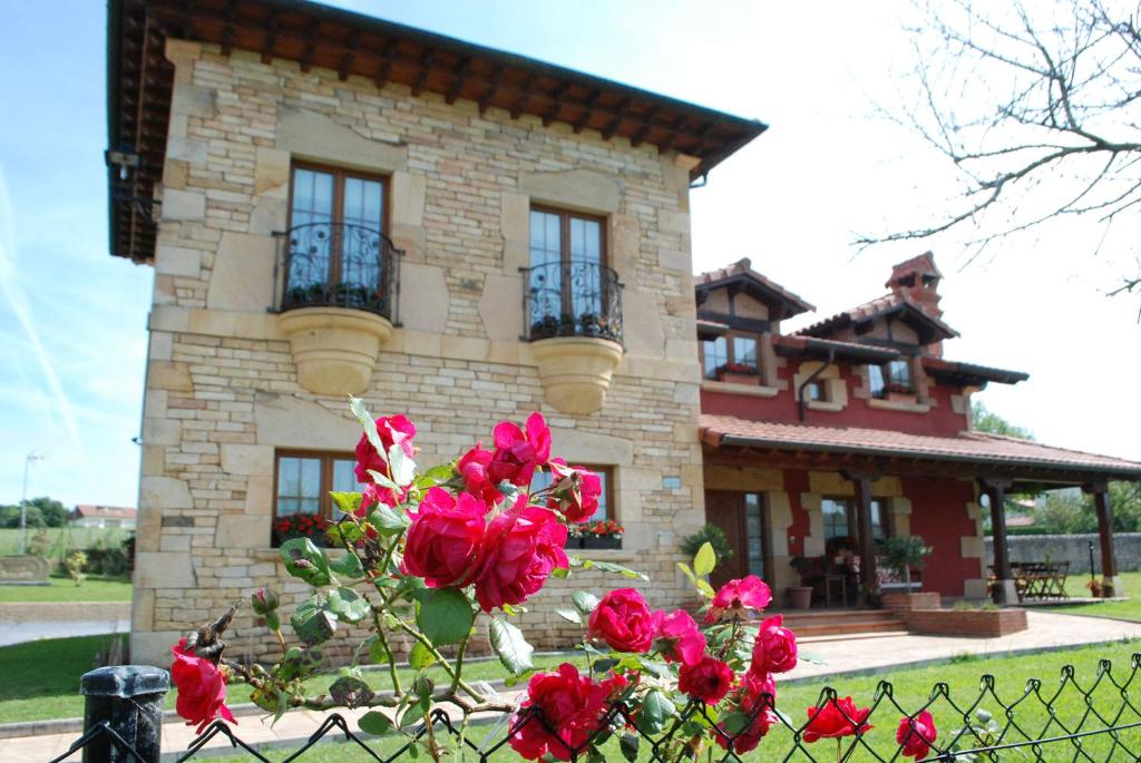桑提亚纳德玛Posada La Fabula的围栏前有红玫瑰的房子