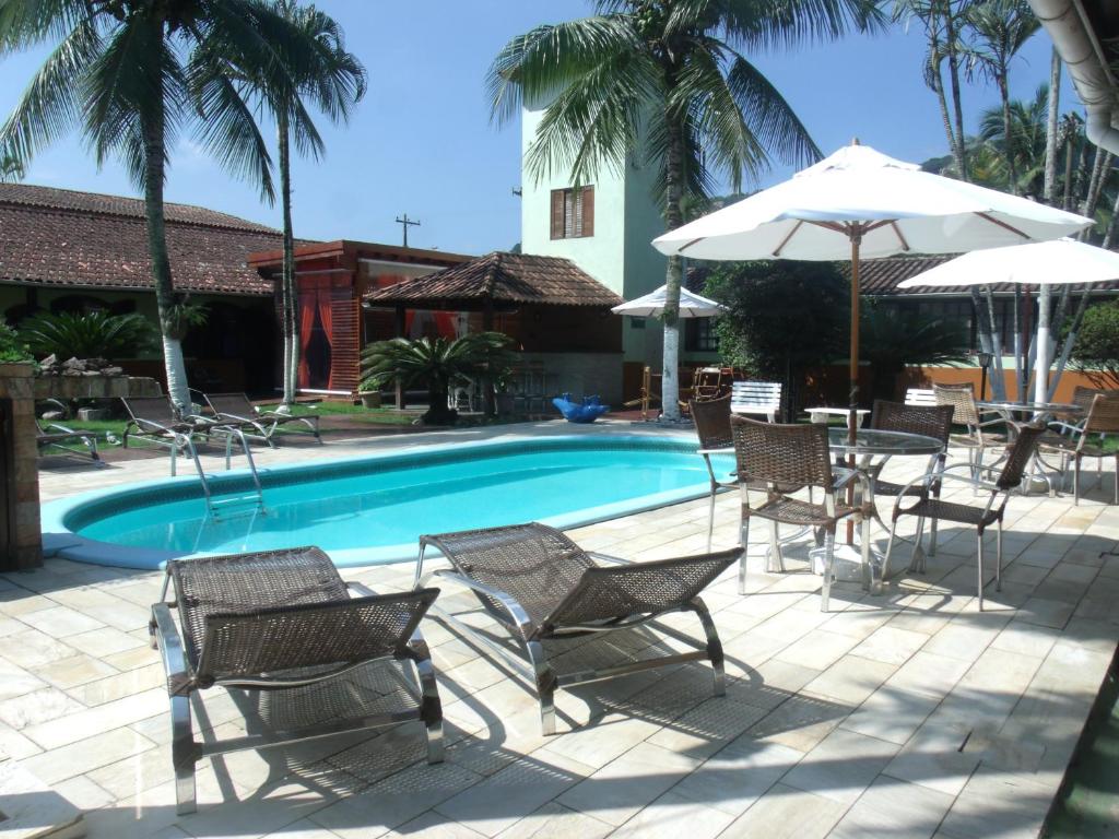 瓜鲁雅快玉吧公寓酒店的一个带桌椅和遮阳伞的游泳池