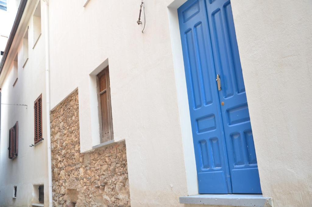 包内伊Guest House Sa Succargia的建筑物一侧的蓝色门