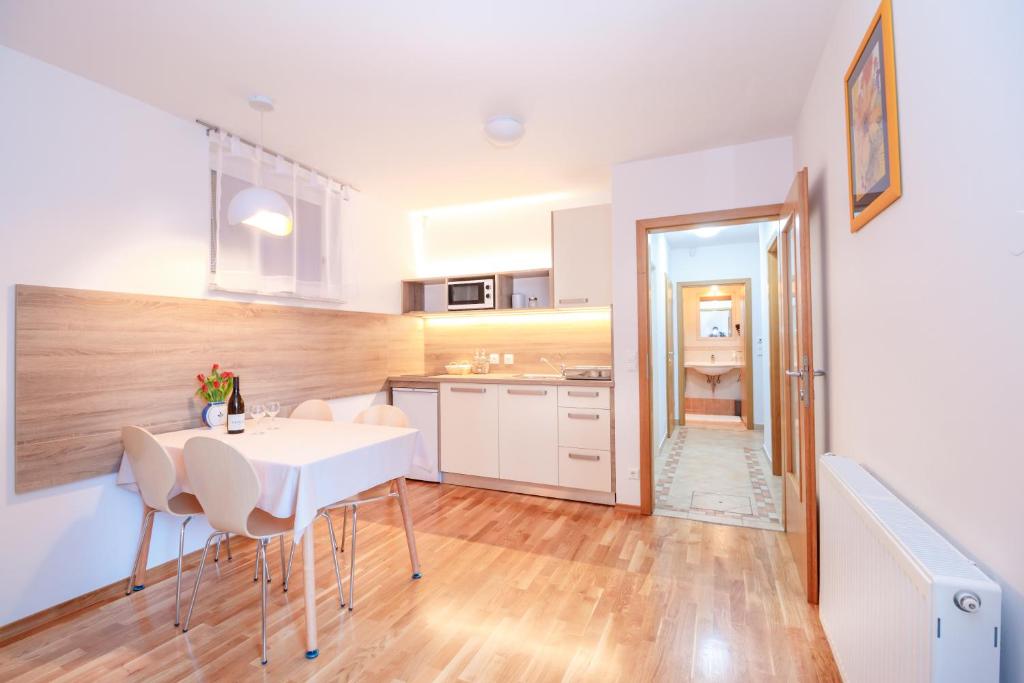 拉多夫吉卡Alp Apartma的厨房以及带白色桌椅的用餐室。
