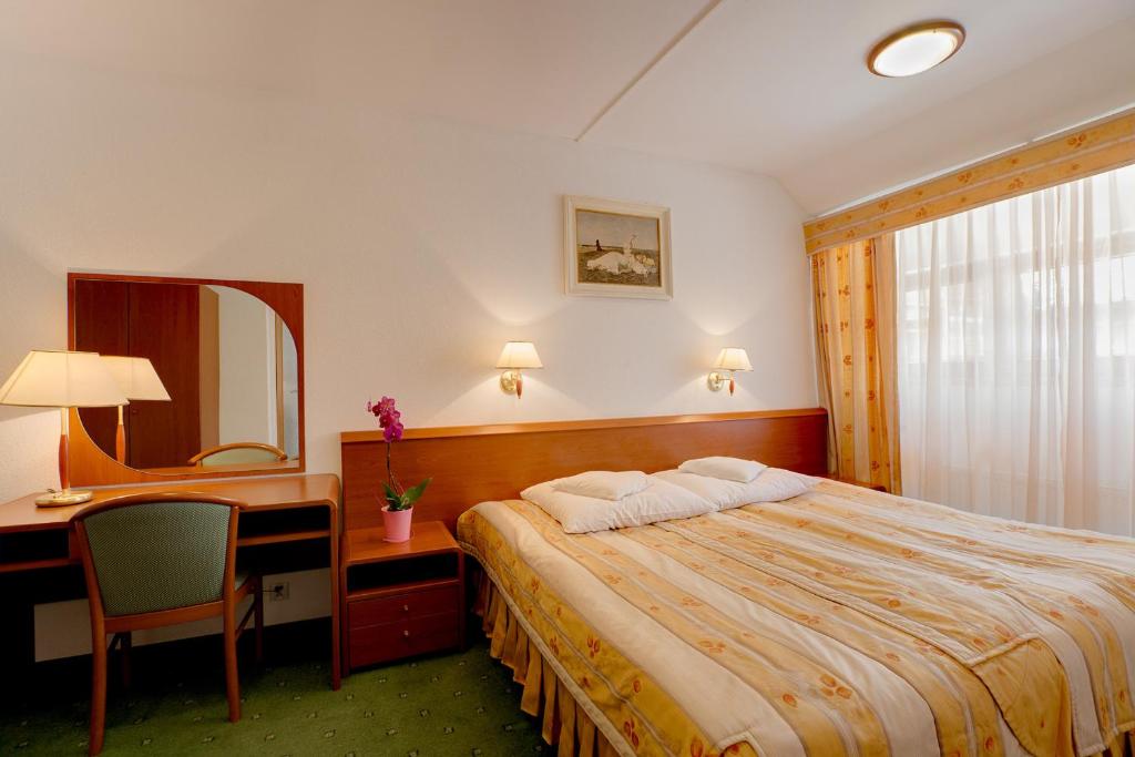 卡齐米日-多尔尼扎亚德皮亚斯特酒店的酒店客房带一张床、一张书桌和一面镜子