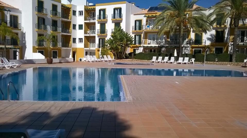 塔维拉Garden Apartment Quinta do Morgado的大楼前的大型游泳池