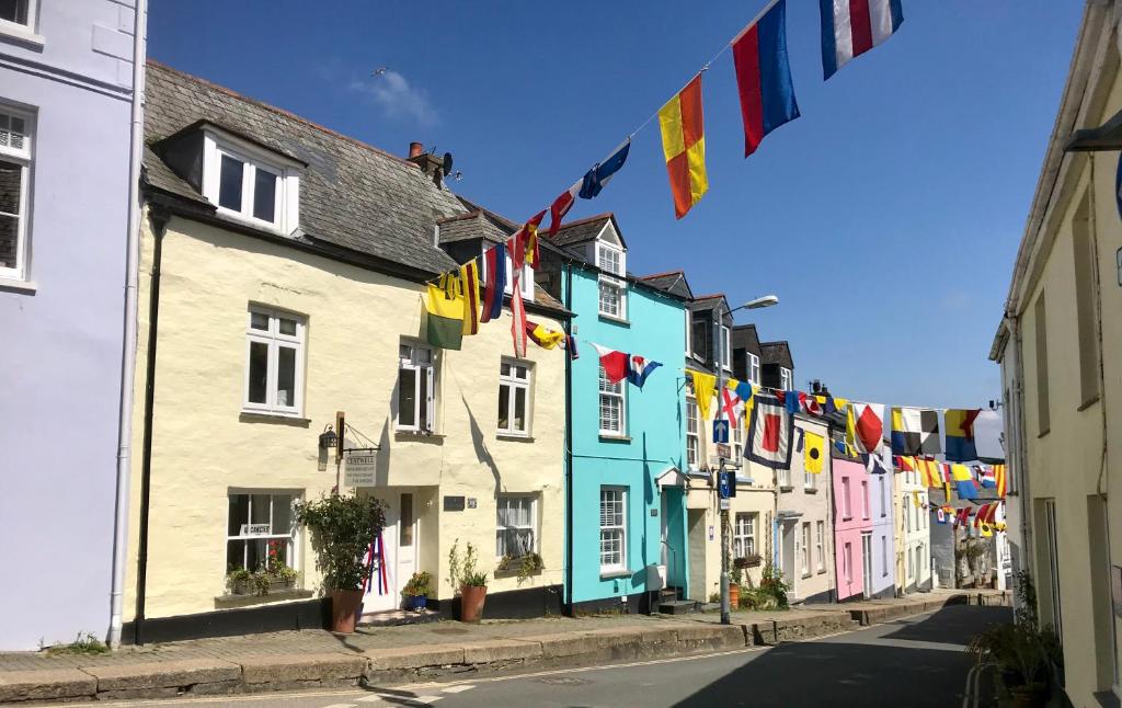 帕兹托Cyntwell Guest Accommodation的街上一排有旗帜的多彩房子