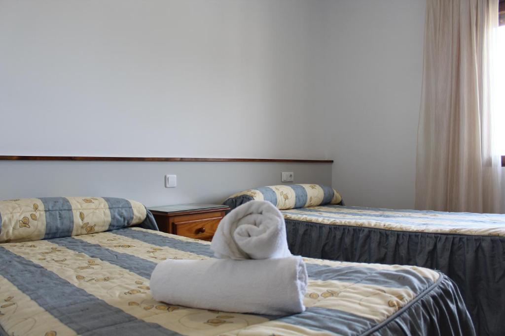 罗德里戈城汨罗布里加旅馆的酒店客房,配有两张带毛巾的床