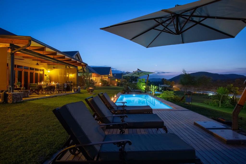 马里兰卡姆巴库河山林小屋的后院设有游泳池、椅子和遮阳伞