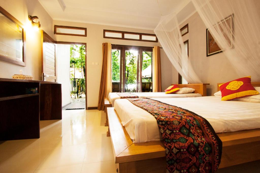 Rabia瓦伊沃拉贾安帕潜水假日公园的一间卧室设有两张床和大窗户