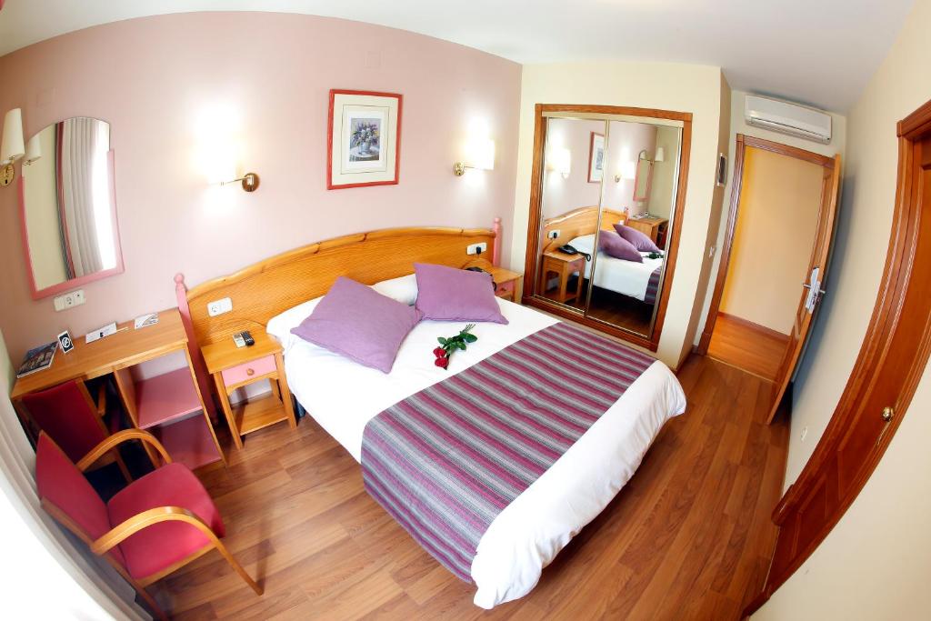 塞戈尔韦玛丽亚卢纳酒店的配有一张大床和镜子的酒店客房