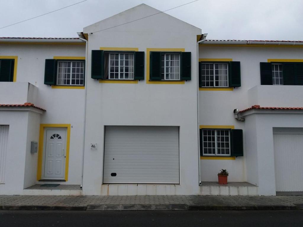 韦拉斯Casa dos Rui´s的白色的房子,设有两个车库门和窗户