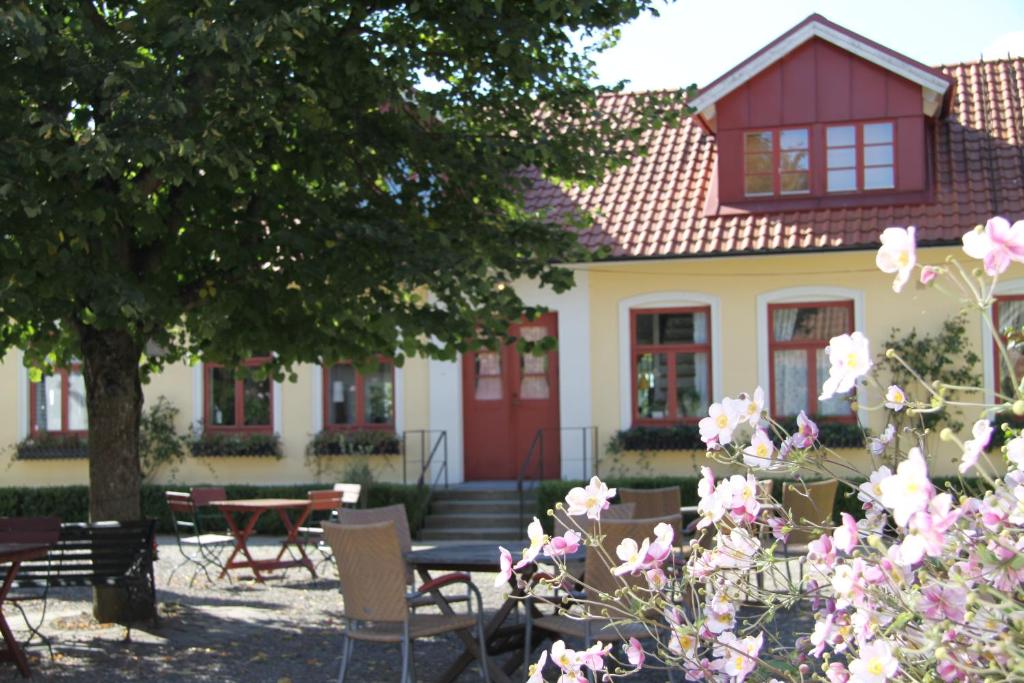 奇维克布拉辛伯格斯嘉德舒特尔旅馆的一座配有桌椅的别墅,并种植了粉红色的鲜花