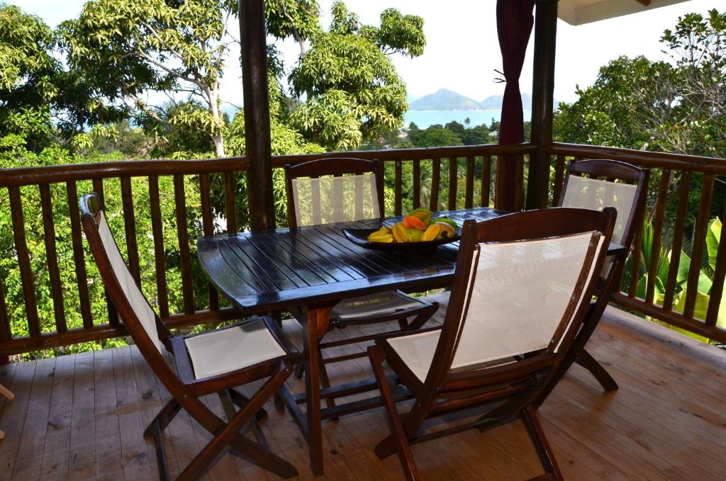 拉迪格岛凯茨拉度瑟住宿加早旅馆的甲板上的一张黑桌子和椅子,上面放着一碗水果