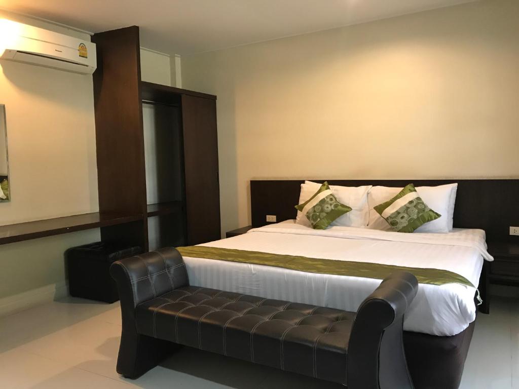 清莱清莱绿园度假酒店的一间卧室配有一张大床和真皮沙发