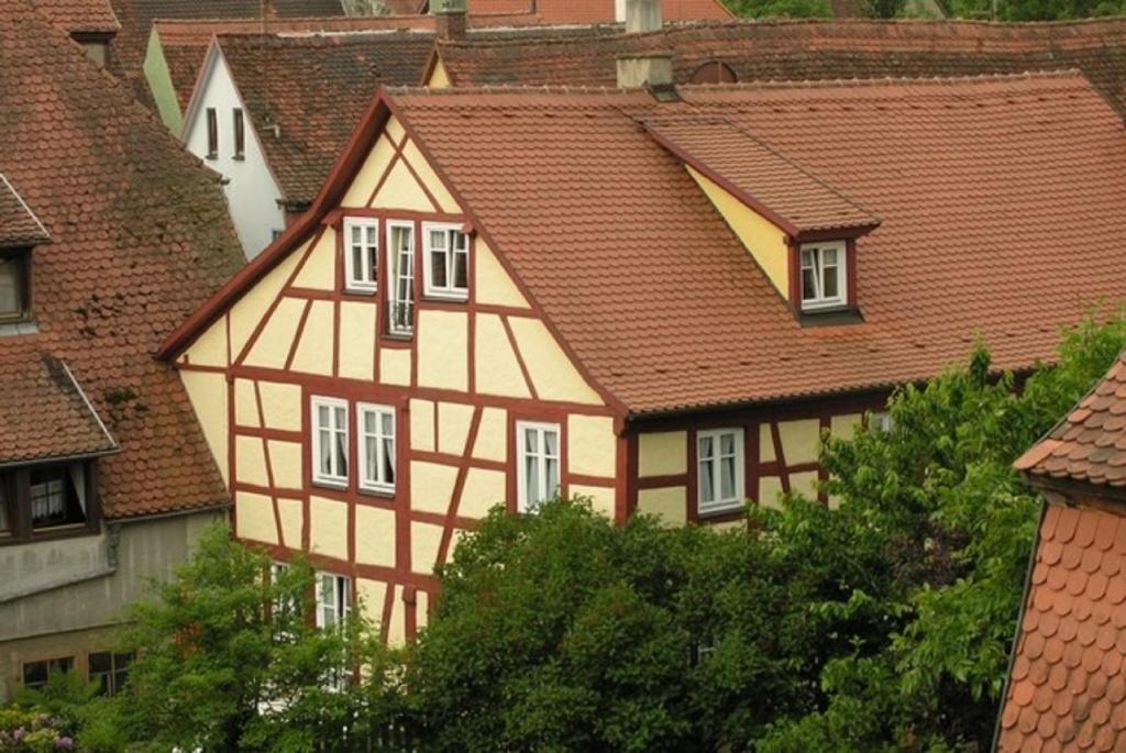 罗滕堡"Am Klingentor (EU)" Ferienwohnungen的黄色和白色的房屋,有红色屋顶