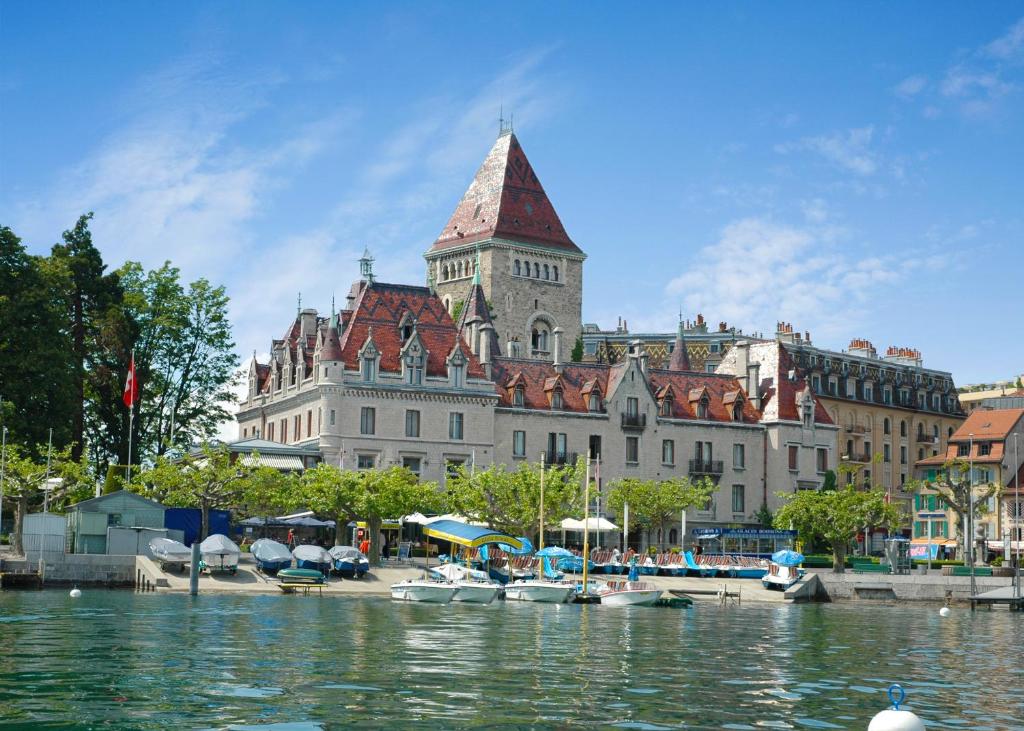 洛桑德奥奇城堡酒店的一座大建筑,在水体旁边设有钟楼