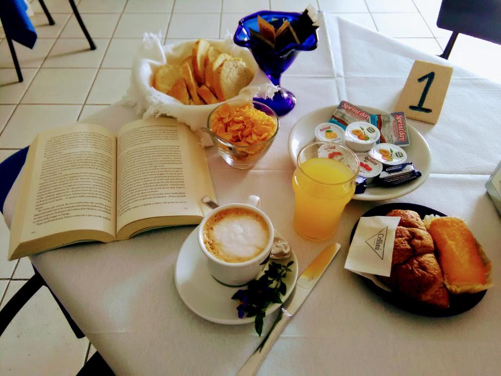 ChiessiB&B da AnnaMaria的桌子,桌子,桌子上放着书,咖啡,盘子
