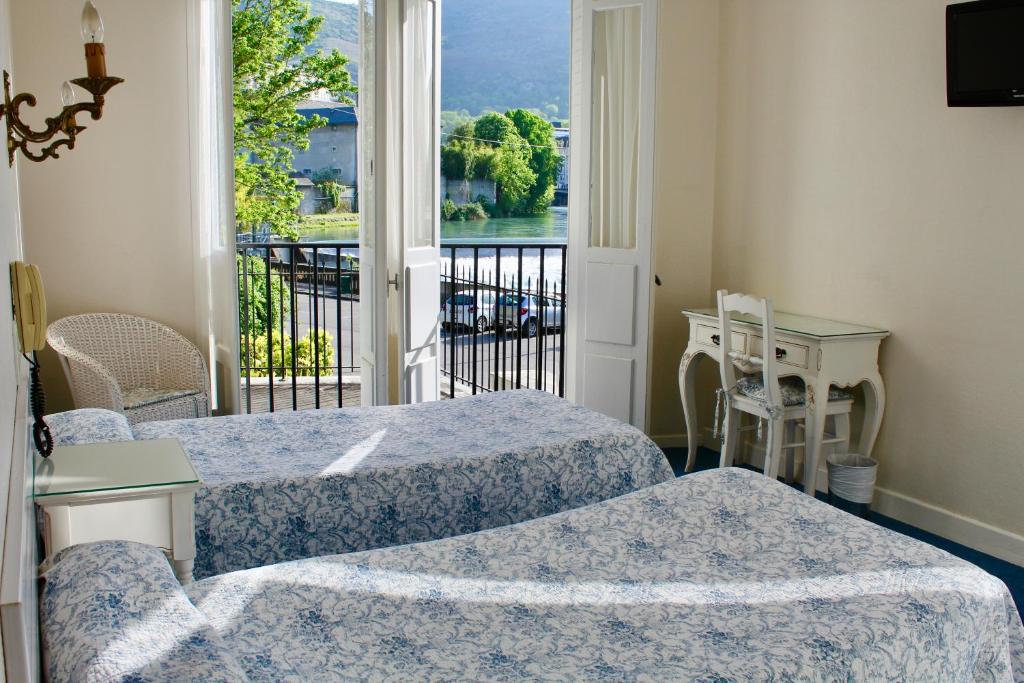 卢尔德Hôtel Sainte Marie的客房设有两张床和一个美景阳台。