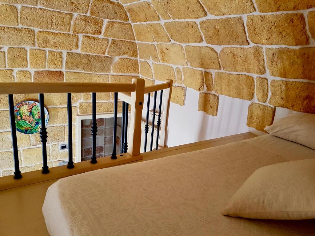 滨海波利尼亚诺Dimora La Nicchia的砖墙房间的一个床位