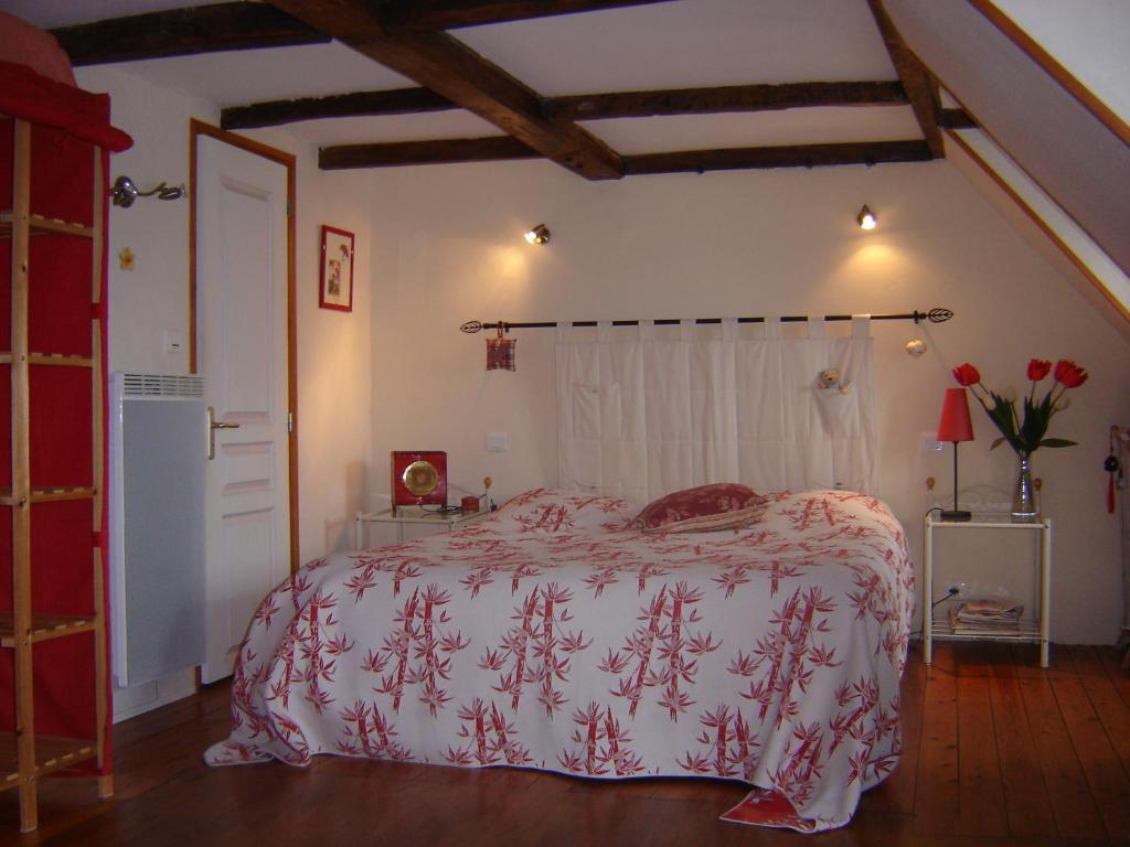 格朗维尔Le Logis du Roc的一间卧室配有一张带红白毯子的床