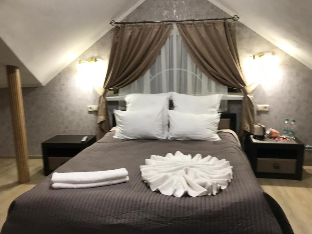 波尔塔瓦Centralnyi hotel的卧室配有一张带白色床单和枕头的大床。