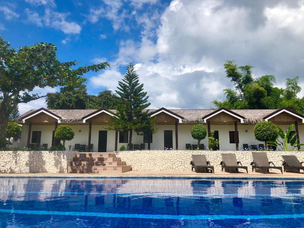 莫阿尔博阿Casa de Moalboal的一个带游泳池和躺椅的度假胜地