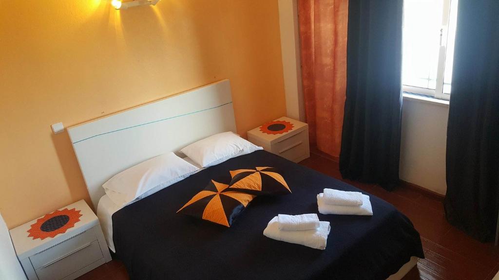 Faja GrandeResidencia Mateus的一间卧室配有带2条毛巾和遮阳伞的床