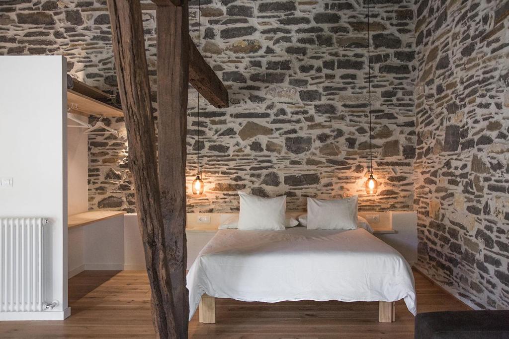 贝尔加拉Izal Landetxea的一间卧室设有石墙、一张床和灯光