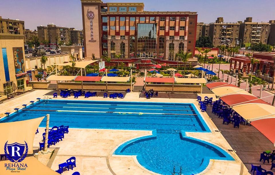 开罗Rehana Plaza Hotel的一座带蓝色椅子的大型游泳池,