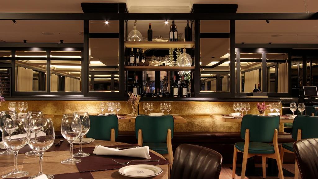 萨穆迪奥阿雷特科萨特酒店的一间带桌椅和酒杯的餐厅
