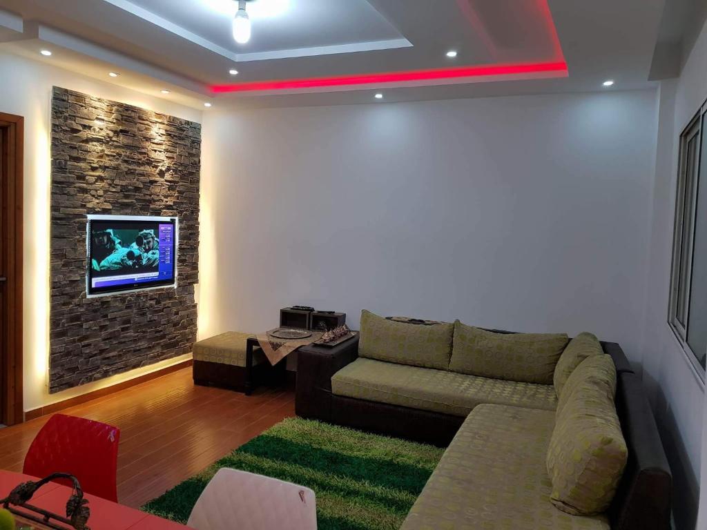 古莱比耶APPARTEMENT "DINA" Kélibia的客厅配有沙发和墙上的电视