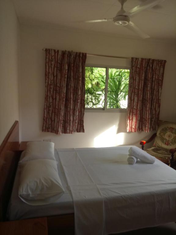 Anse KerlanAwesome Charlie D Villas的一间卧室设有两张床和窗户。