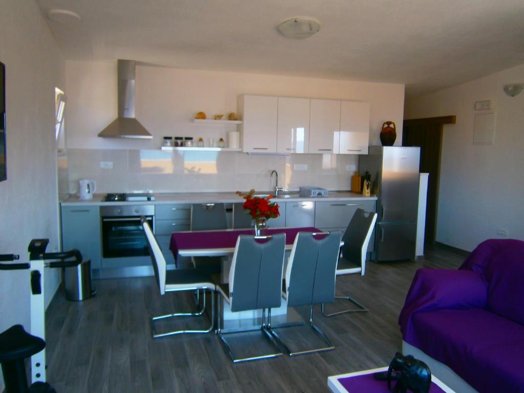 科米扎Apartment Willy的厨房以及带桌椅的起居室。
