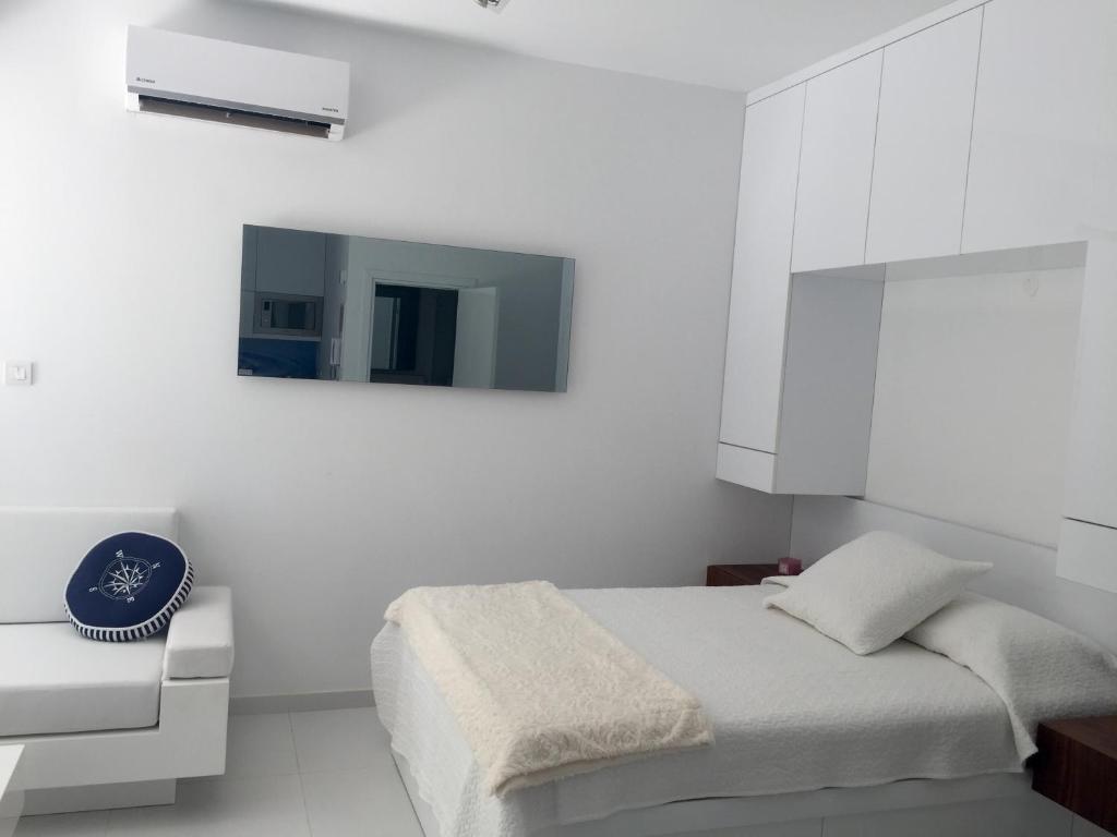 利马索尔Modern Seaview Beach Studio Limassol的一间白色卧室,配有床和电视