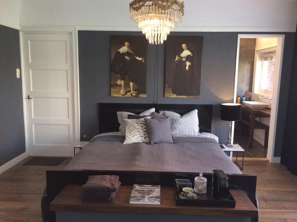 埃因霍温Florentino的一间卧室配有一张带桌子和绘画的床