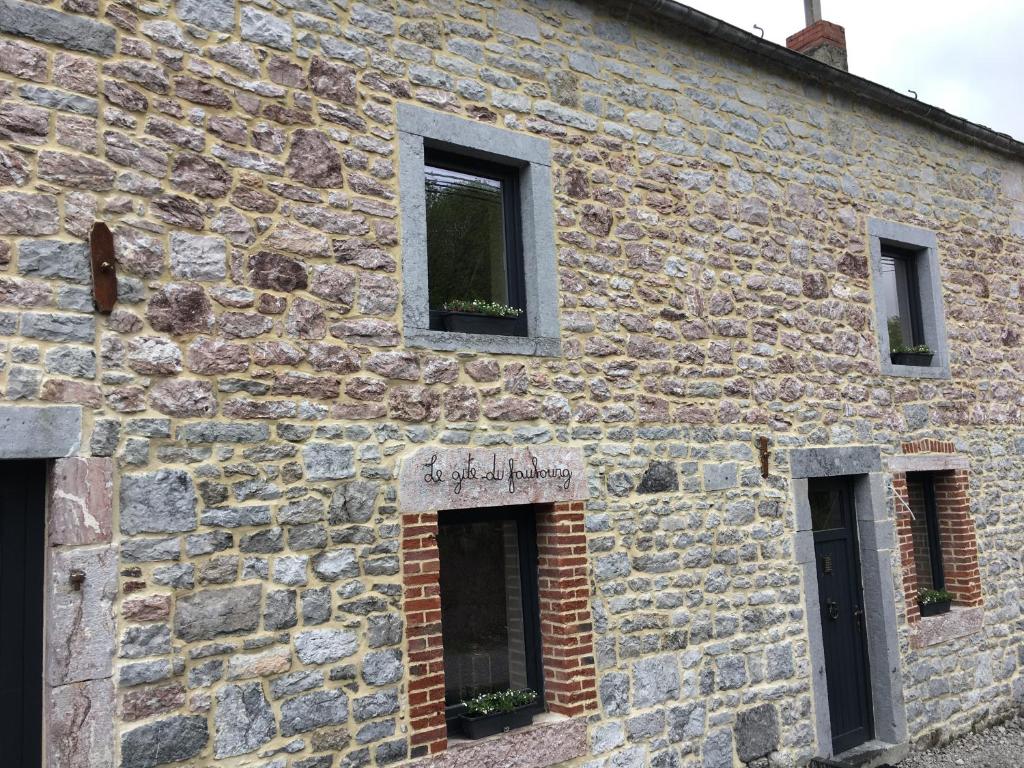 SautourLe gîte du faubourg的一座古老的石头建筑,有三个窗户