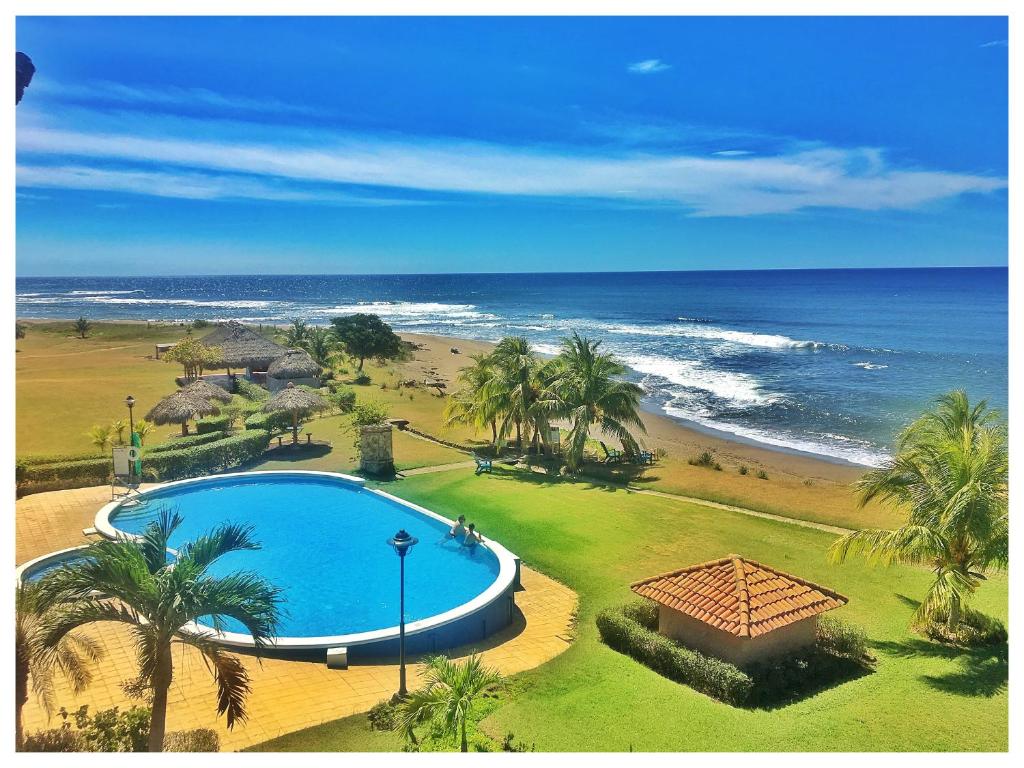 圣地亚哥Suite San Juan 133 Gran Pacifica Resort的享有游泳池和海滩的上方景色