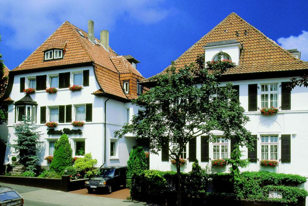 巴特萨尔茨乌夫伦豪斯莫尔斯酒店的一座大型白色房屋,设有红色屋顶
