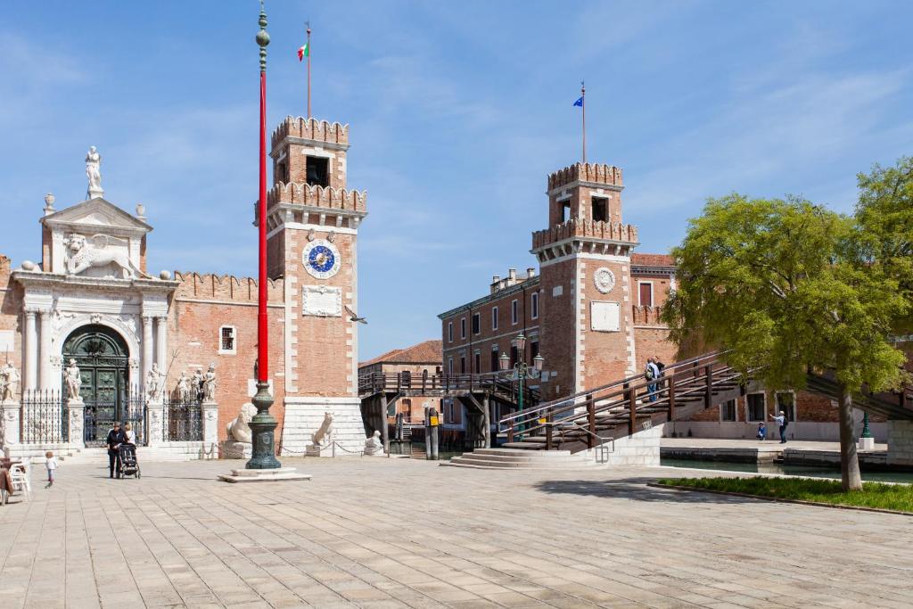 威尼斯Prince Apartments的一座大型砖砌建筑,前面有一个钟楼