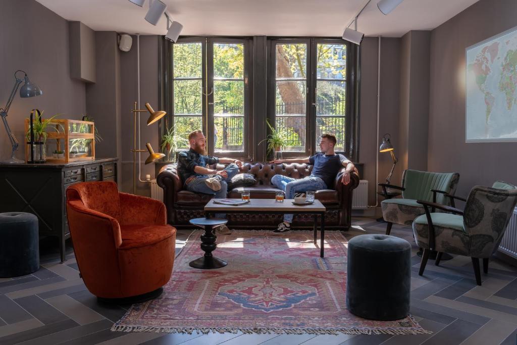 阿姆斯特丹Stayokay Hostel Amsterdam Vondelpark的两人坐在客厅的沙发上