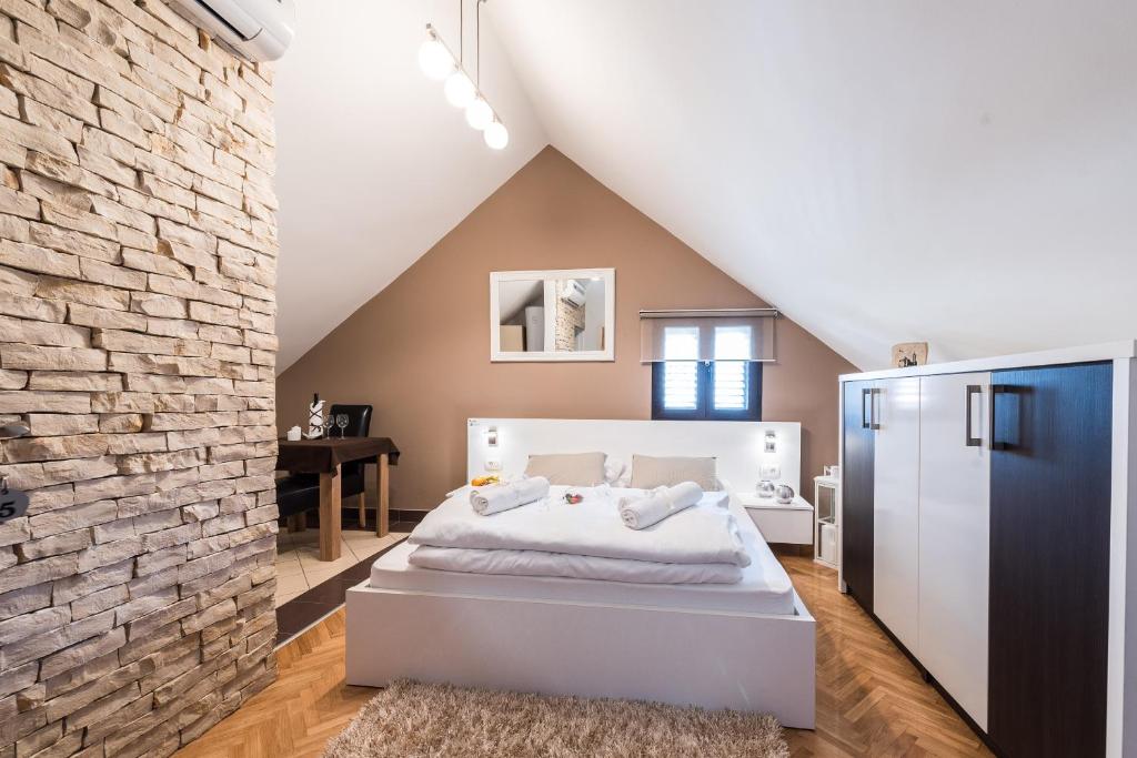 扎达尔多纳特公寓酒店的卧室配有白色的床和砖墙