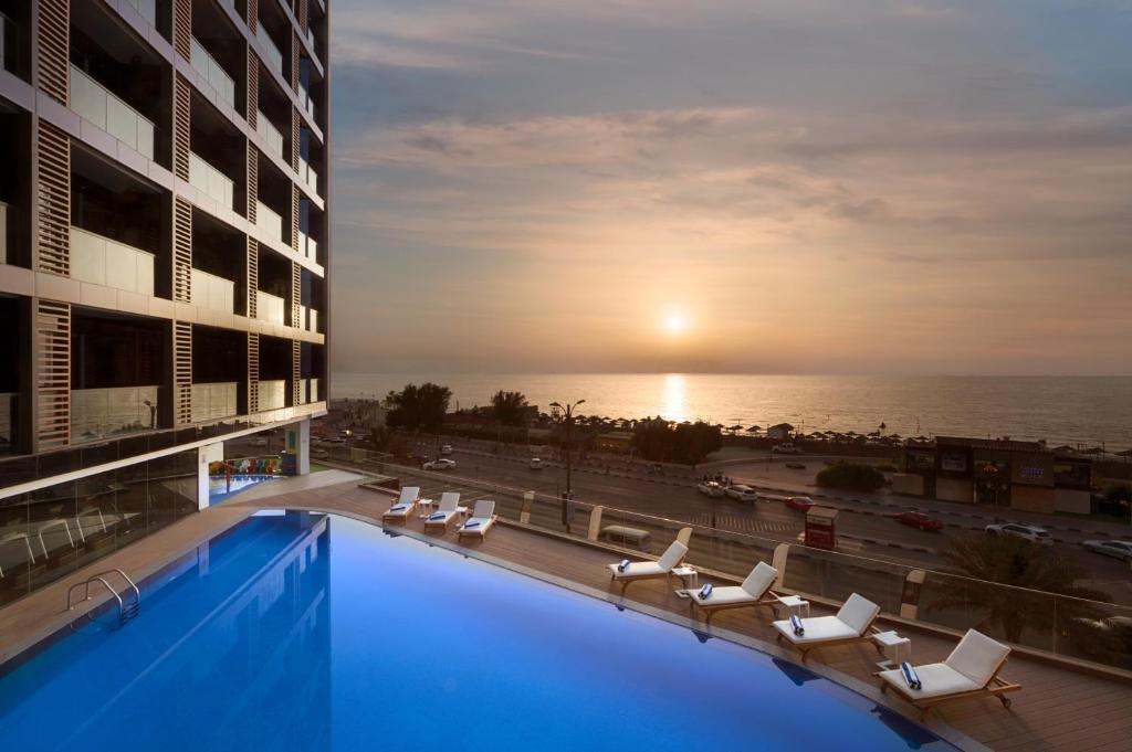 阿吉曼Wyndham Garden Ajman Corniche的酒店游泳池享有海景