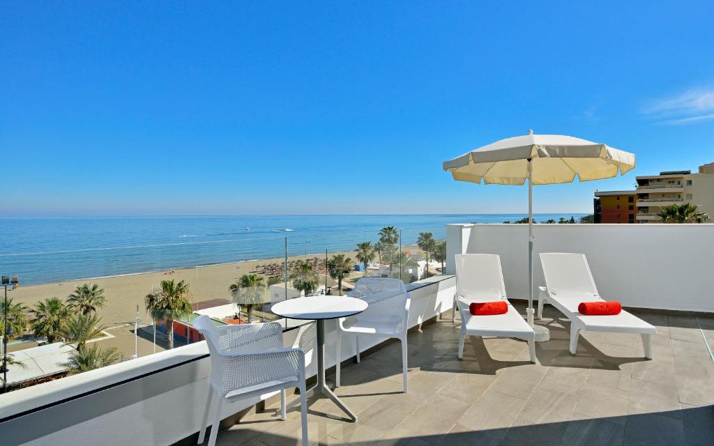 多列毛利诺斯Sol Torremolinos - Don Marco Adults Recommended的一个带桌椅和海滩的阳台