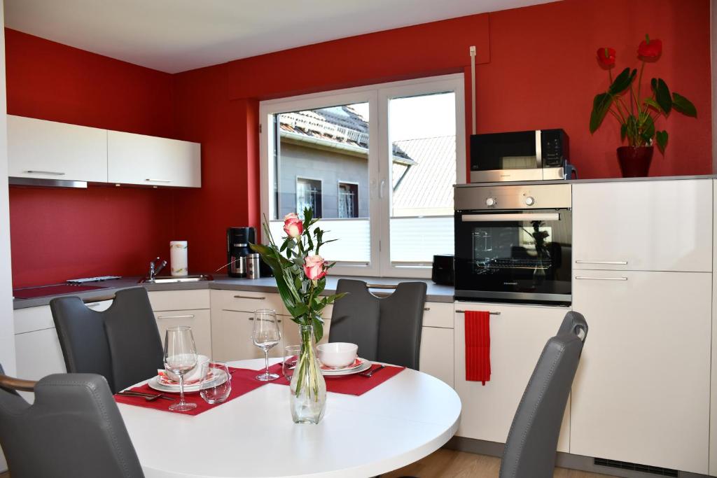蒙绍Eifellounge的厨房设有红色的墙壁和花瓶桌子