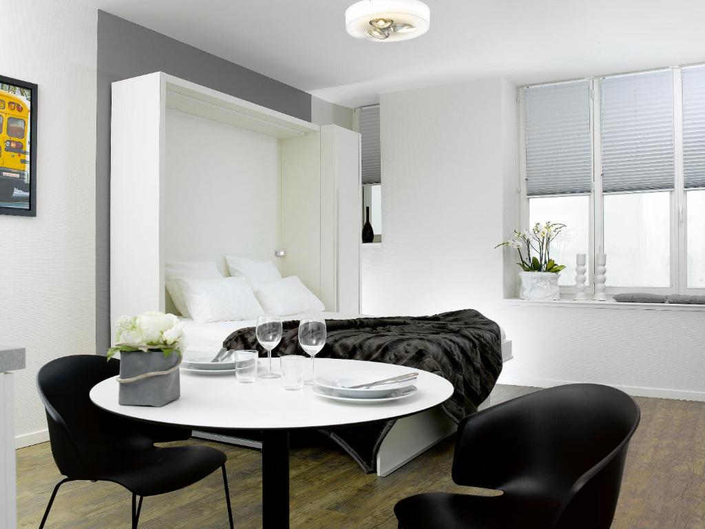 斯特拉斯堡32套公寓酒店的客厅配有桌椅和1张床