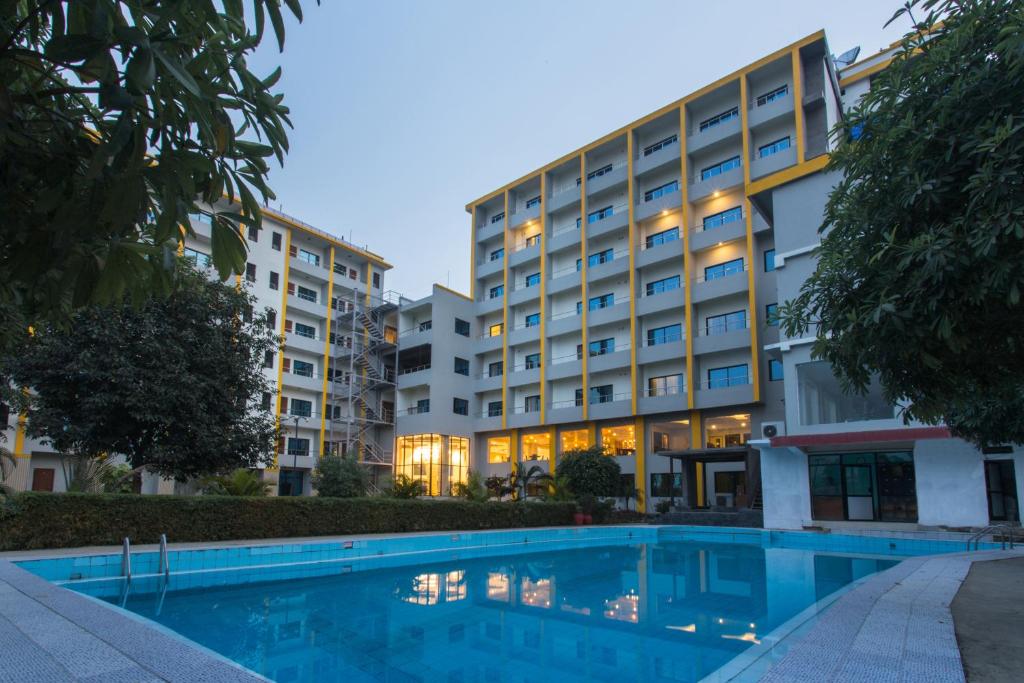 尼泊尔根杰Hotel Siddhartha, Nepalgunj的大楼前设有游泳池的酒店