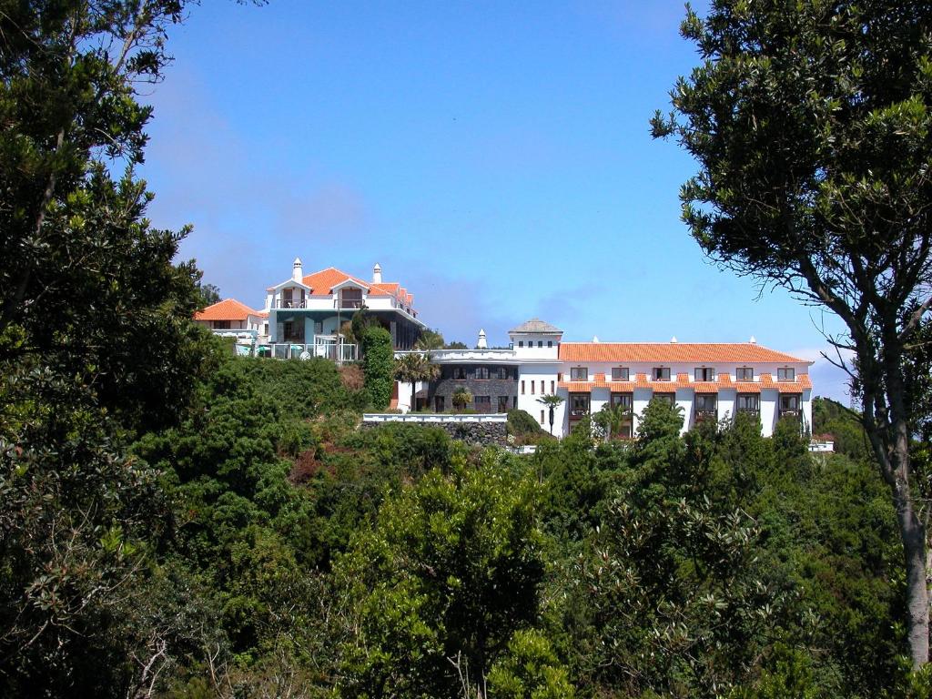巴尔洛文托拉帕尔玛浪漫酒店的一座树荫小山顶上的大型房屋