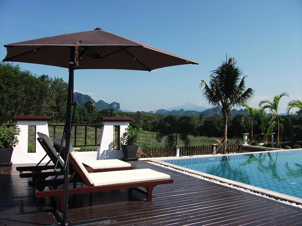 班奥南矛利拉瓦地花园度假村的游泳池旁带遮阳伞的桌子