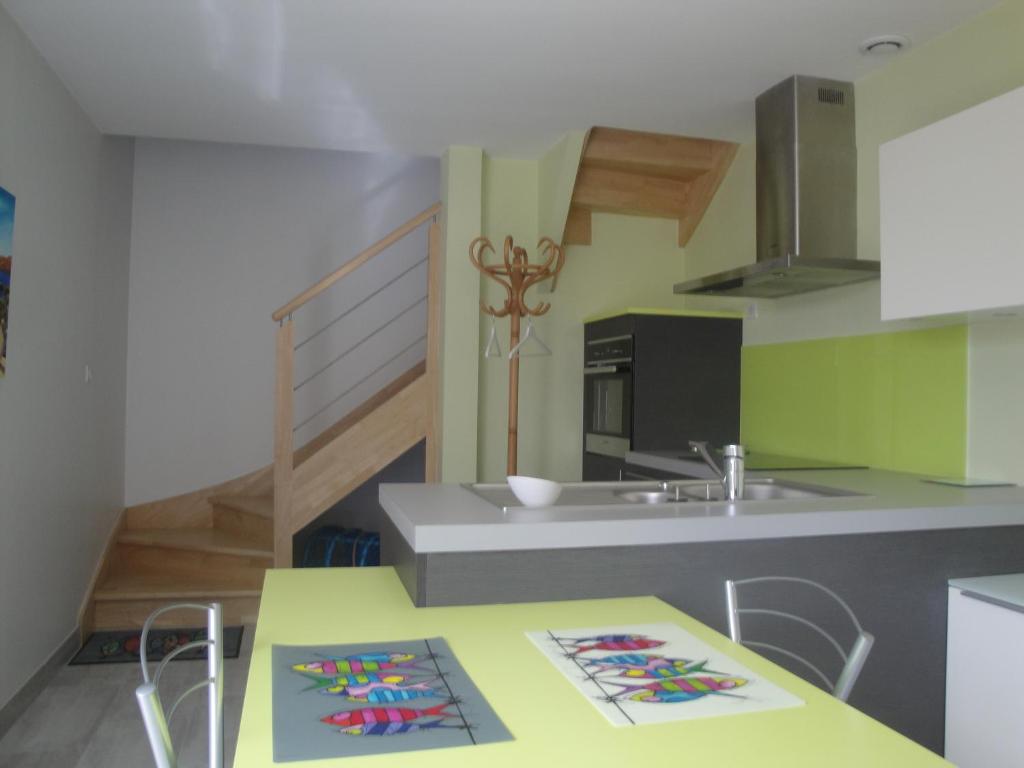 孔卡尔诺Maison de vacances的厨房配有黄色桌子和水槽