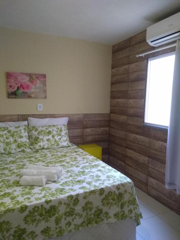 阿拉卡茹Anauê Pousada e Hostel的一间卧室配有一张带绿色和白色毯子的床