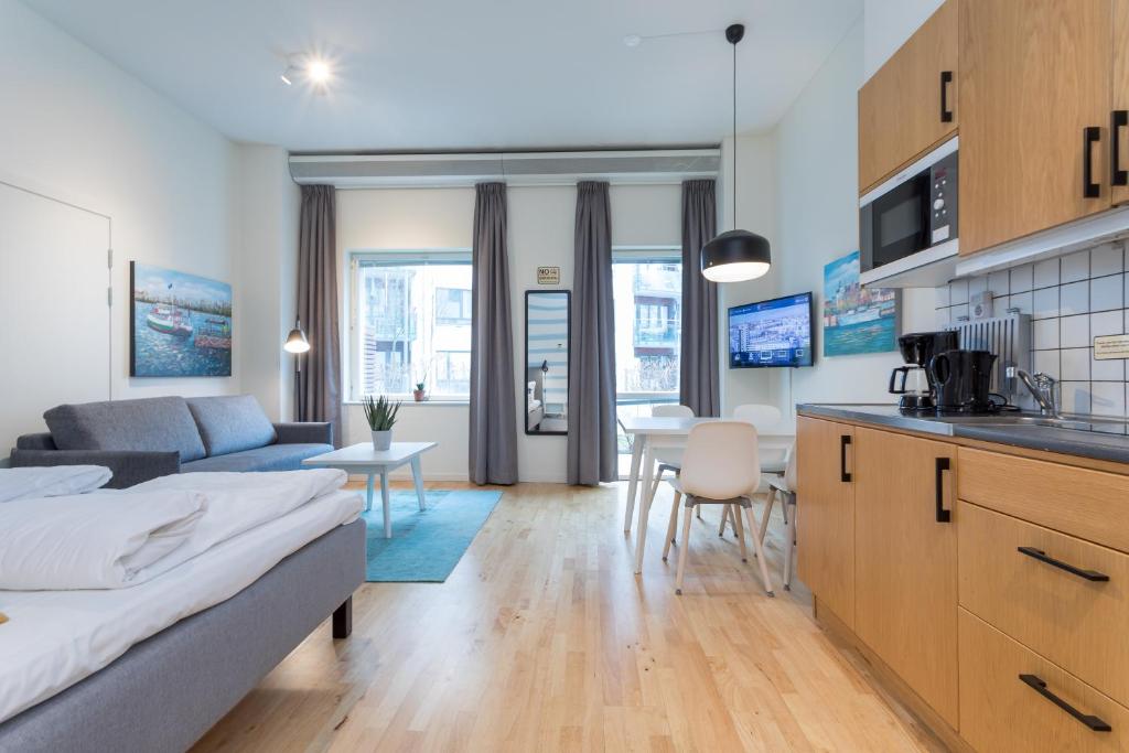 斯德哥尔摩ApartDirect Hammarby Sjöstad的厨房以及带床和沙发的客厅。